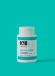 A bottle of K18 PEPTIDE PREP detox shampoo against a teal background.